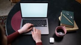 Seorang kreator konten sedang menyusun narasi pribadi di situs web miliknya sembari menikmati suasana tenang di sebuah kedai kopi. Kemudahan pengelolaan platform digital kini memberikan kemerdekaan penuh bagi individu untuk mempublikasikan karya tanpa batasan algoritma media sosial.